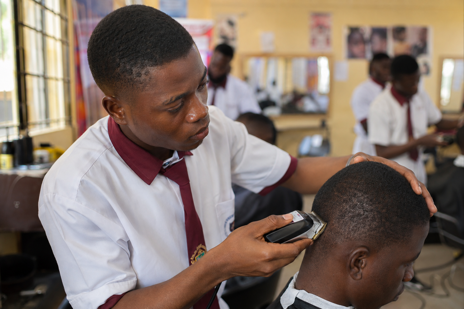 A trainee practicing a professional haircut with clippers during a barbing vocational class